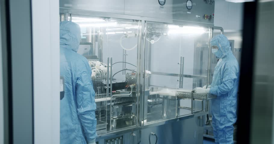 Factory Cleanroom. Pharmaceutical, Biotechnological and Semiconductor Creating Manufacturing Process. Scientists in Sterile Protective Clothing Work on a Modern Laboratory. Royalty-Free Stock Footage #1104189747
