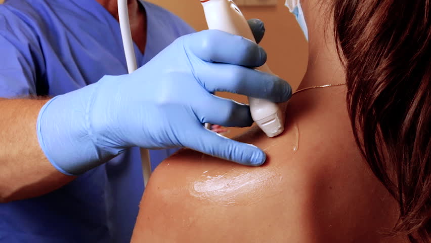 Doctor doing shoulder ultrasound scan exam on patient, young woman. Shoulder examination with an US probe. Utrasound technician Royalty-Free Stock Footage #1104190063