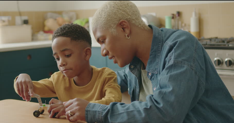 Mother and Son Playing with STEM Toy at Kitchen table