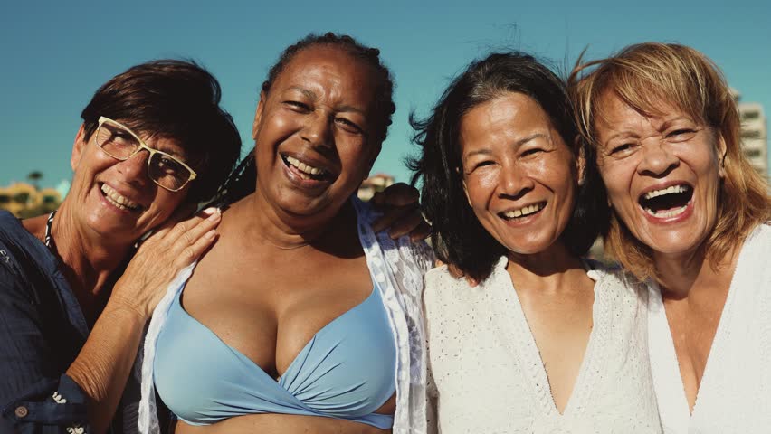Happy multiracial senior women having fun smiling into the camera on the beach - Diverse elderly people enjoying summer holidays Royalty-Free Stock Footage #1104196211