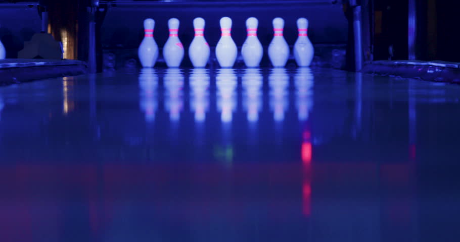 The video captures the moment when the man successfully throws the ball in bowling, causing all the pins to fall except for one.