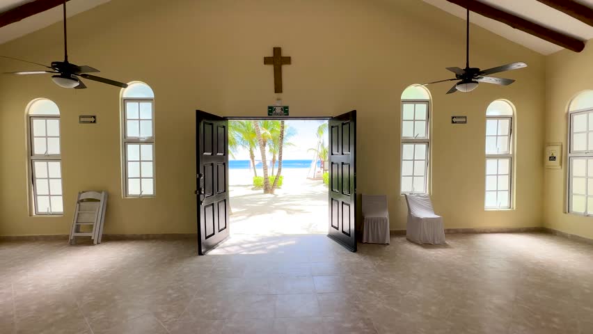 Walking from church out to a tropical beach with green palm trees, sandy beach and ocean in the background