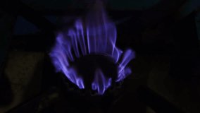 Blue flame of the stove in the kitchen. Kitchen gas stove fire inflaming, close-up burner flame. Gas and energy concept 4k video. 
