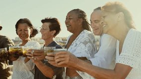Happy multiracial senior friends having fun drinking and toasting mojitos on the beach during sunset time - Elderly people enjoying summer holidays - Powered by Shutterstock - Get 15% off with code: PIKWIZARD15
