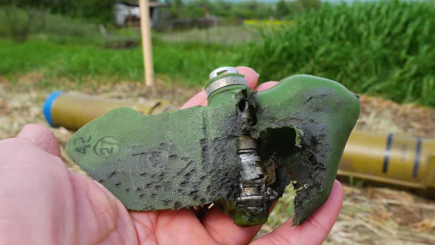 A torn anti-personnel mine damaged by an explosion, a petal in his hand. Demining of the territory. Russian-Ukrainian War 2022-2023 Royalty-Free Stock Footage #1104206771