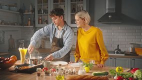 Charismatic bearded macho boiling Italian pasta, while cooking with his girlfriend in the home kitchen interior. Happy couple sharing happy moments together, enjoying preparing romantic dinner for two - Powered by Shutterstock - Get 15% off with code: PIKWIZARD15