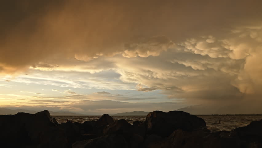 Panning view of clouds at sunset following storm over Utah Lake looking across the valley.