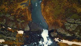 Oxarafoss waterfall drone sho, majestic icelandic huge cascade flowing down off hills. Beautiful landscape with river stream running off cliffs in iceland. 60 fps video.