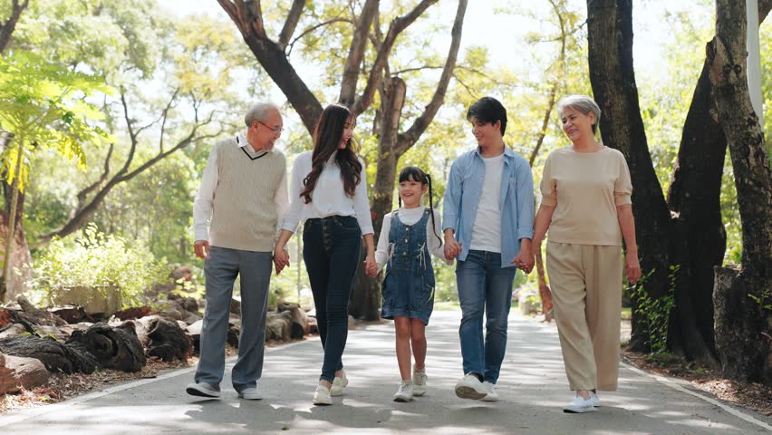 Happy big Asian family on summer walking together in the public park , Multi-generation family walking in the outdoor garden