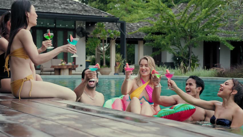 Groups of Multiculturalism Friends clink glasses fun in pool party, School holiday vacation trip at private pool villa Royalty-Free Stock Footage #1104221119