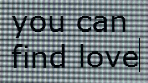 "you can find love" being typed on computer screen in close up so that individual pixels can be seen