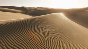 Shiny golden sand on top of rippled dunes in sunset light. Cinematic aerial background with ripples texture on sand surface in desert nature in low sunshine. Incredible shot strong wind blowing sand - Powered by Shutterstock - Get 15% off with code: PIKWIZARD15
