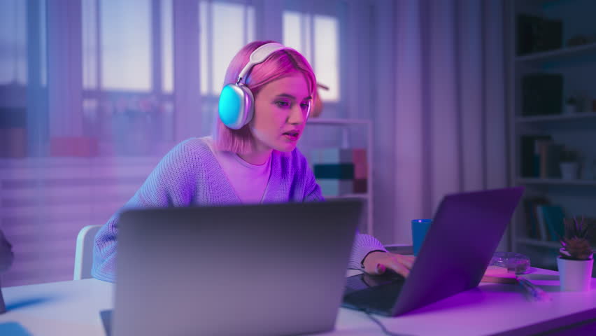 Positive young woman celebrating video game victory, having good time at home