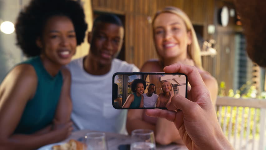 Smiling group of smiling friends on holiday outdoors together posing for picture on mobile phone - shot in slow motion Royalty-Free Stock Footage #1104226905