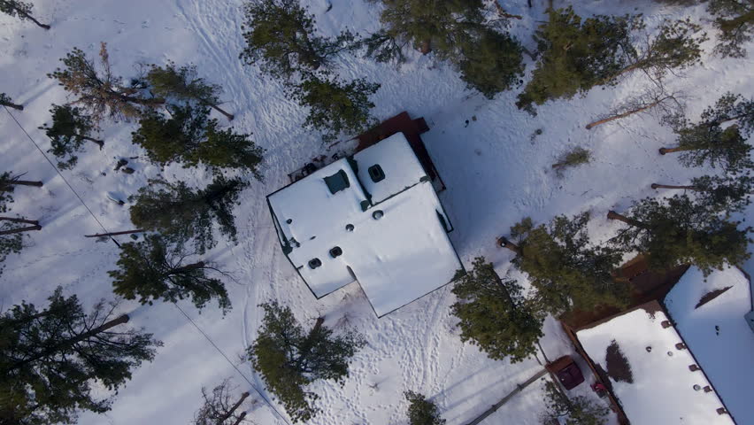 Top Down Aerial Shot Over Snow Topped House in Town of Grand Lake in Colorado, USA. Birdseye view snowy roof.