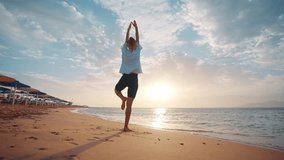 Yoga on the beach. Woman practicing yoga on coastline of the ocean. Beautiful woman relaxing on the beach. Silhouette of a slender beautiful woman at sunrise. Healthy active lifestyle, vitality, zen. - Powered by Shutterstock - Get 15% off with code: PIKWIZARD15