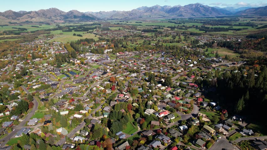 Hanmer Springs village in New Zealand, aerial wide panoramic. Urban landscape, sunny day, autumn colours