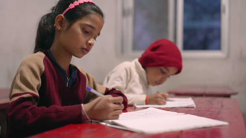 Indian children studying and taking notes in the classroom, primary school, learning and education concept. 