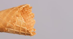Vertical video 4K footage, Scoop ice cream vanilla into a cone on a gray background.