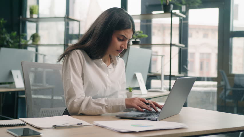 Arabian stressed businesswoman gen z Indian business woman working in office with computer laptop and paperwork problem failure search information trouble with documents difficulties financial mistake Royalty-Free Stock Footage #1104235059