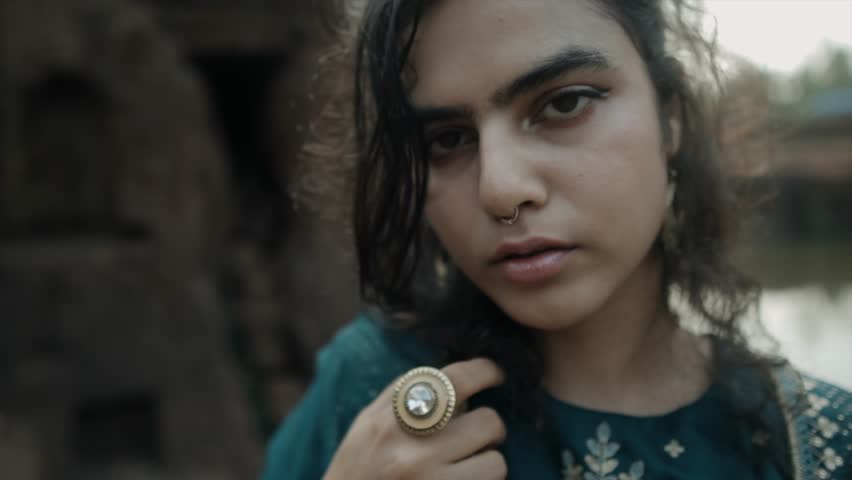 attractive girl closeup zoom out, nose piercing, ring, robe, mysterious and cute, eye contact.  Royalty-Free Stock Footage #1104235871