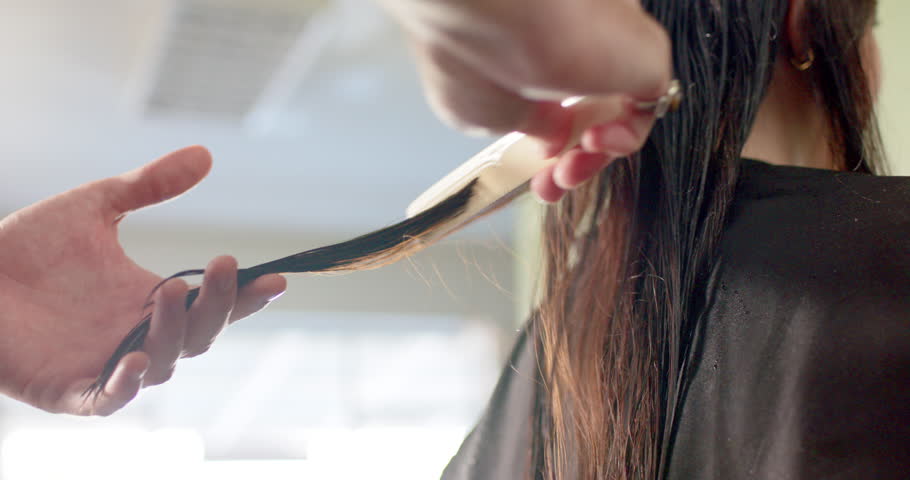 Hands of caucasian male hairdresser combing client's long hair at hair salon, slow motion. Local business, work, hairdressing, hair care and hairstyling, unaltered. | Shutterstock HD Video #1104243919