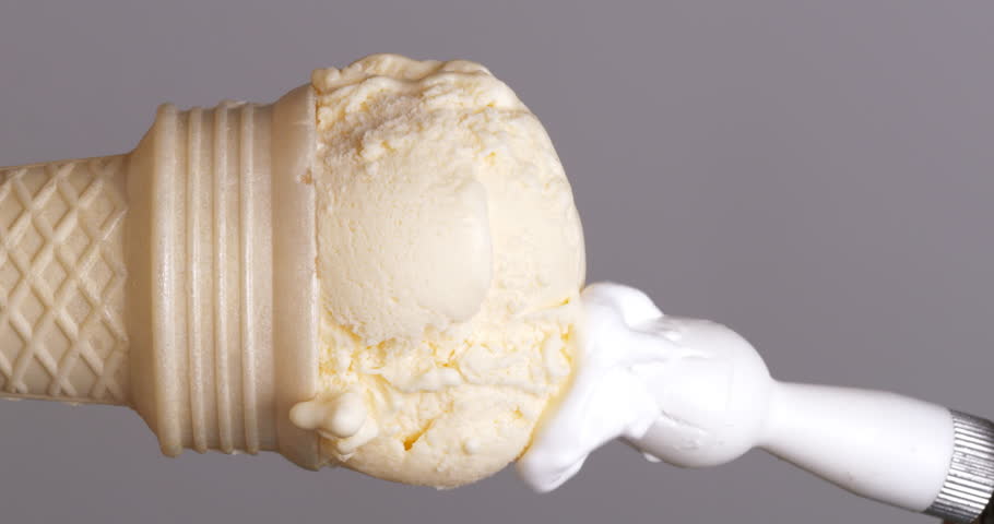 Vertical video 4K footage Front view SLO MO CU, Squeeze white whipped cream over a vanilla ice cream cone on a gray background. | Shutterstock HD Video #1104244249