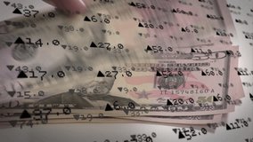 Animation of stock market data processing over close up of hand keeping dollar bills on grey surface. Global economy and business technology concept - Powered by Shutterstock - Get 15% off with code: PIKWIZARD15
