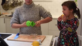 mother and daughter cooking together in kitchen home video