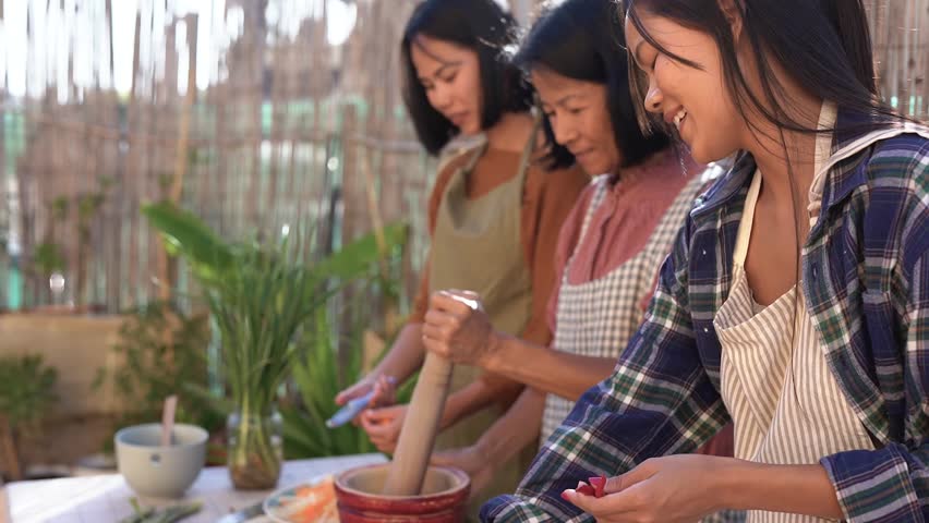 Happy asian mother cooking with adult daughters at house terrace - Family, culture and traditional thai food concept Royalty-Free Stock Footage #1104253263