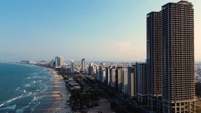 Aerial 4K footage of Da Nang coastline. My Khe beach seafront with high-rise hotels and skyscrapers in the golden sand beach