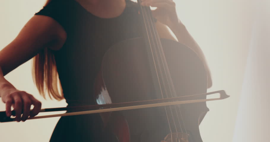 Single woman playing the cello, close-up and medium close-up, cello bow and strings, smooth transitions of the camera from focus to out-of-focus, beautiful filmic, artistic shots. Royalty-Free Stock Footage #1104255637