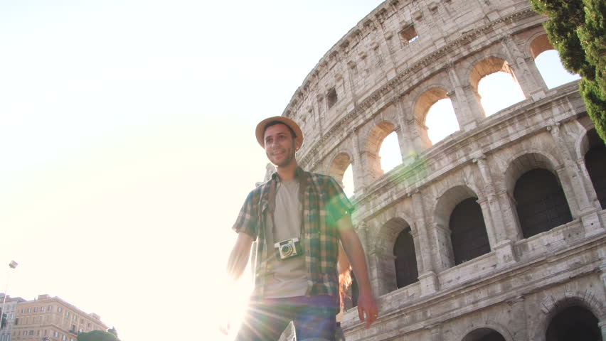 Lovely young couple at Colosseum, piggyback spreading arms at sunrise. Rome, Italy. Royalty-Free Stock Footage #1104256981
