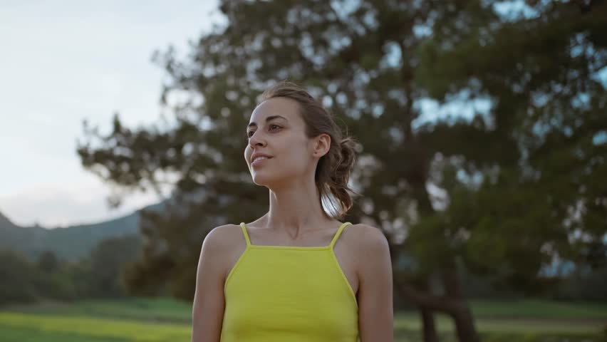 slow motion portrait of Young Athlete Woman enjoyinng beautiful green rural field landscape after running outdoors along Green Fields. Royalty-Free Stock Footage #1104258451