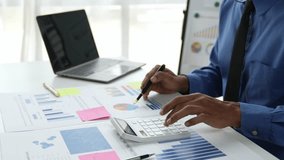 Asian businessman working in the office, calculating financial reports, organizing paperwork using a laptop and calculator as an aid. management concept accounting.	 - Powered by Shutterstock - Get 15% off with code: PIKWIZARD15