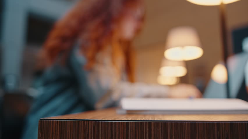 Girl preparing for an exam in a campus library, using a laptop to access online study material for her course. Female university student putting in hard work and dedication towards her academics.