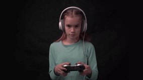 4k female gamer in headphones and with joystick in hands playing video games