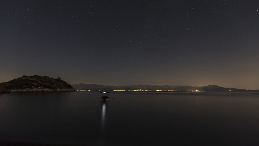 Timelapse shot of the night sky by the sea. Many stars are visible. There is a boat on the sea. | Shutterstock HD Video #1104274979