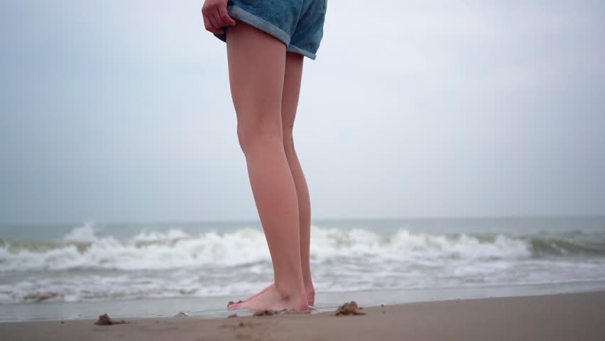 Close up of person bare feet walking at tropical beach. People playing barefoot at tropical beach. Having fun jumping in sea water on warm sunny day on seashore. Summer travel and vacation concept. | Shutterstock HD Video #1104276029
