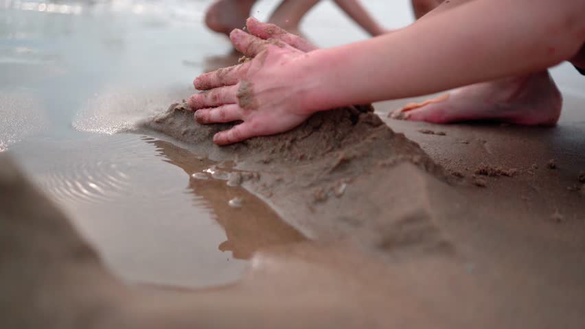 Children on summer vacation making on beach building sand castle together. kids playing with at tropical beach. enjoying playing warm sunny day on seashore. Family, Holiday and Travel concept. | Shutterstock HD Video #1104276033