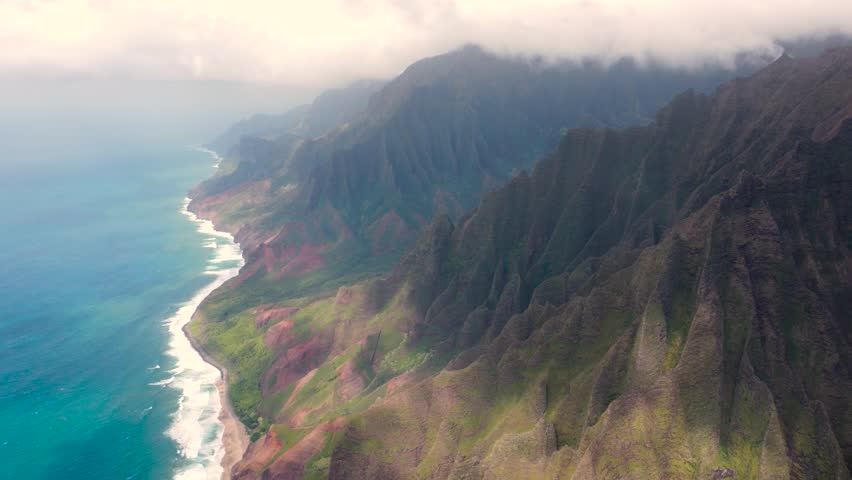 Amazing aerial view of Napali Coast Kauai island Hawaii USA with dramatic mountains, blue ocean . Drone flying over green jungle mountain peaks revealing tropical beach Tropical coastline | Shutterstock HD Video #1104277211