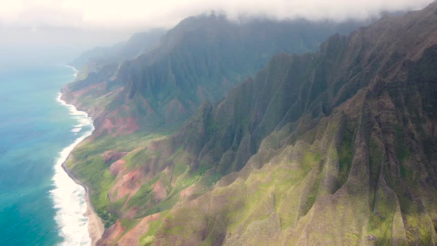 Cinematic Aerial view of Napali Coast Kauai Hawaii USA with dramatic mountains, blue ocean . green jungle mountain peaks tropical beach on Na Pali park. breathtaking mountain ridge Kokee State park | Shutterstock HD Video #1104277213