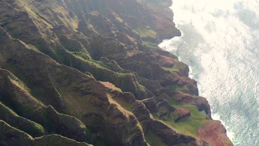 Aerial view of Napali Coast Kauai island Hawaii USA with dramatic mountains, blue ocean . Green jungle mountain peaks, tropical beach on Na Pali park. breathtaking mountain ridge Kokee State park | Shutterstock HD Video #1104277217