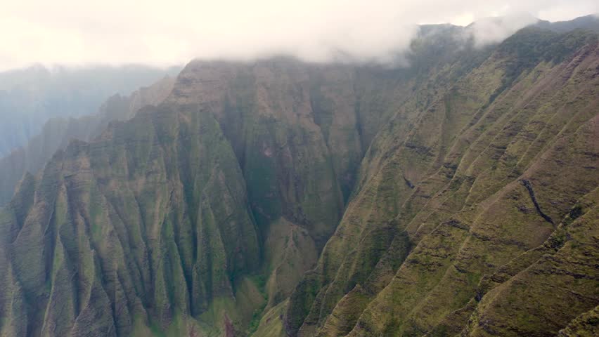 Panoramic aerial view of Napali Coast Kauai island Hawaii USA with dramatic mountains, blue ocean . drone flying over green jungle mountain peaks tropical beach on Na Pali park. Tropical coastline | Shutterstock HD Video #1104277411