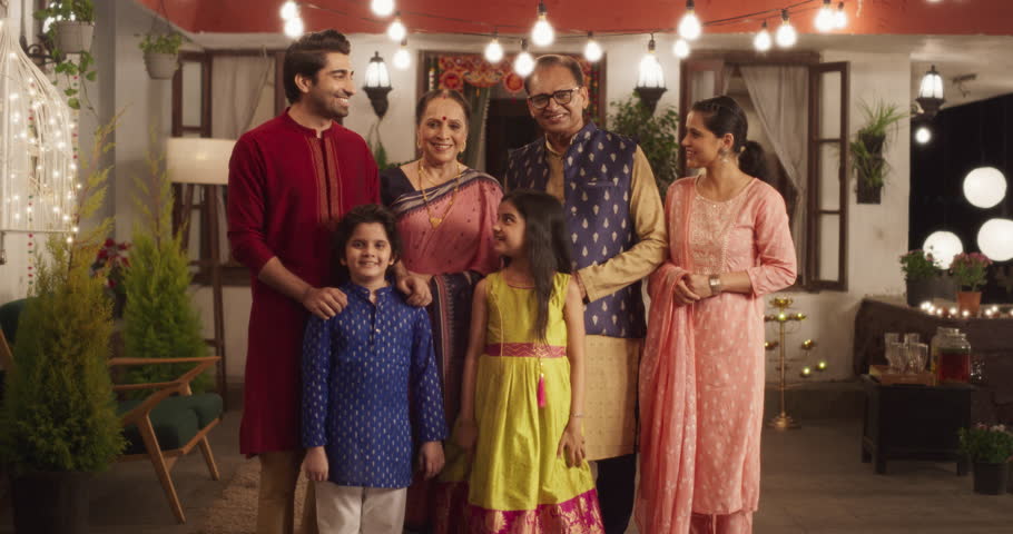 Portrait of Happy Indian Family in Traditional Clothes Laughing and Posing Together in Authentic Mumbai House. Gorgeous Parents, Grandparents, and Cute Kids Looking at the Camera. Zoom in Slow Motion