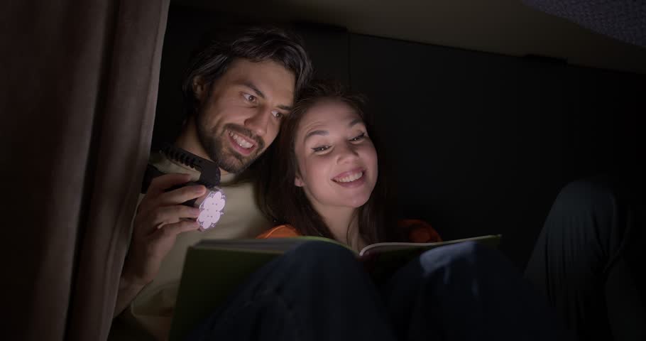 Cozy Homemade Shelter for Two: Reading and Happiness in the Dark Royalty-Free Stock Footage #1104287333
