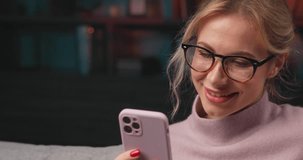 Portrait of a smiling woman using a mobile phone and watching funny videos.