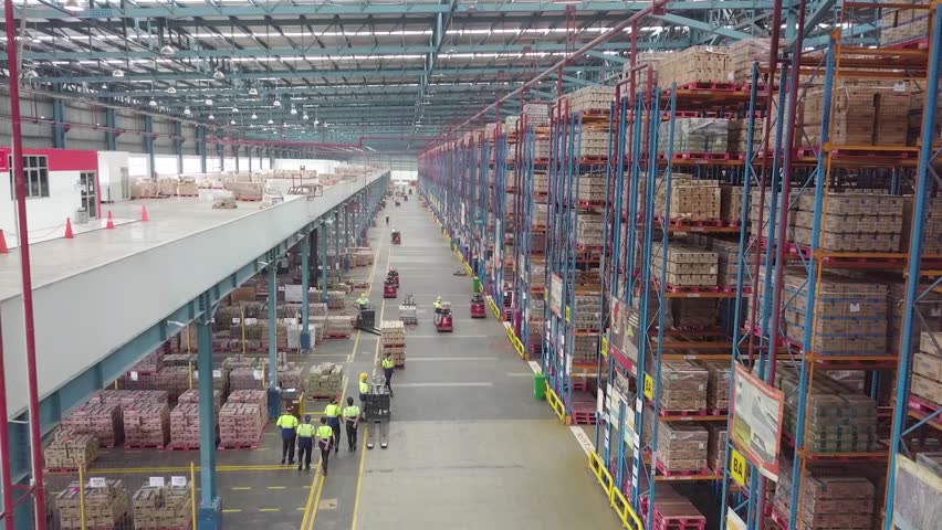 Delivery Warehouse full of shelves with goods in cardboard boxes, workers sort packages, move inventory with pallet trucks and Forklifts. Product Distribution Logistics Center. Asia. Royalty-Free Stock Footage #1104288901