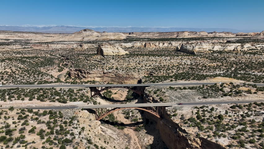 Aerial Eagle Canyon highway bridge traffic high fly over Utah 1. San Rafael Reef geologic landscape central Utah. Eroded into tall fins, domes, cliffs, and deep canyons. wilderness desert environment.