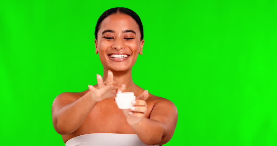 Portrait, skincare and cream with a black woman on a green screen background in studio for beauty. Facial, cosmetics and lotion with a happy young female model indoor to apply antiaging treatment Royalty-Free Stock Footage #1104290569